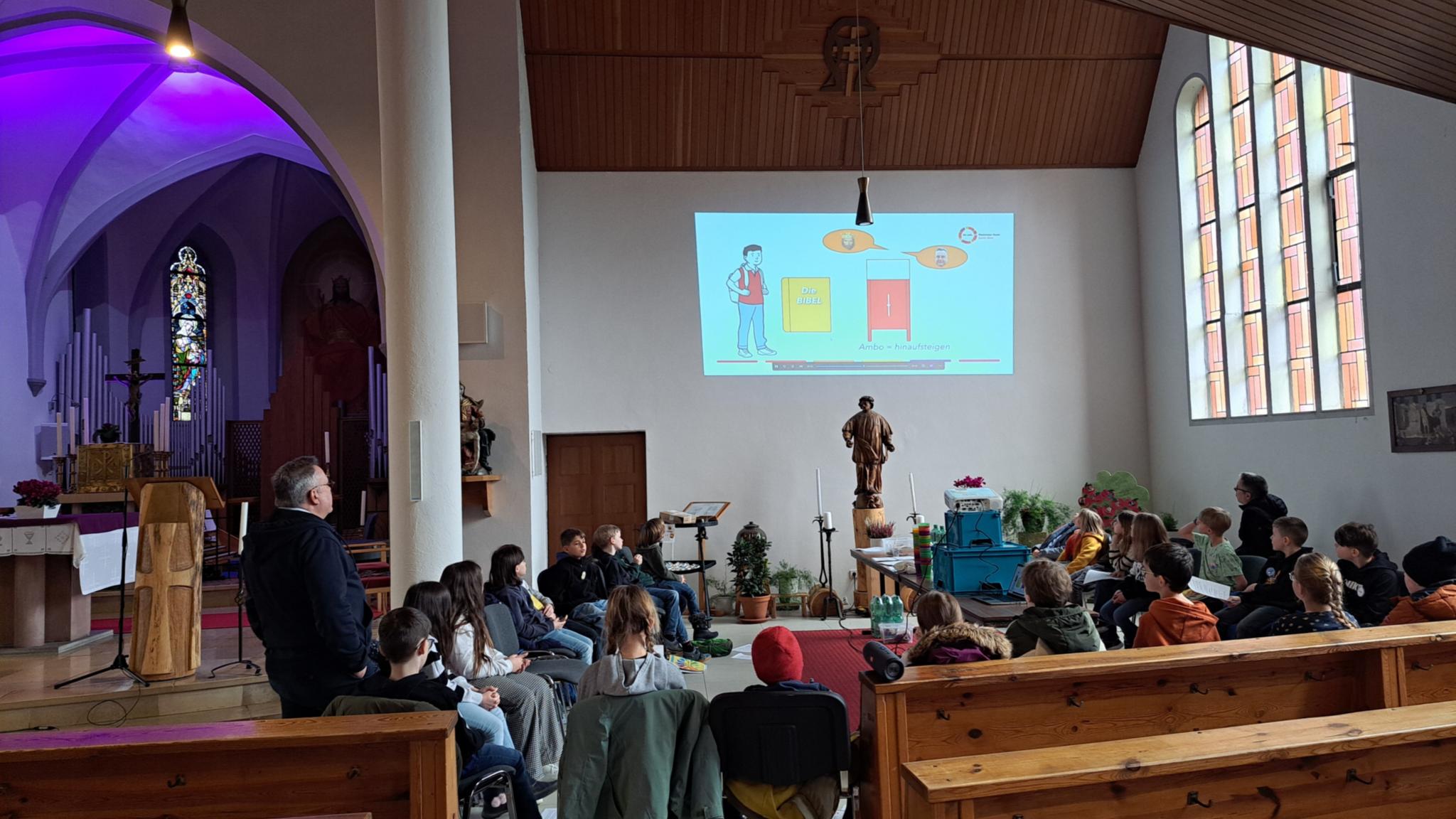 Die Kommunionkinder schauen das Erklärvideo 'Wir entdecken den Kirchenraum'